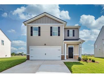 Charming two-story home with a two-car garage and well-manicured lawn in a suburban neighborhood at 12106 Conrad Cir, Hampton, GA 30228