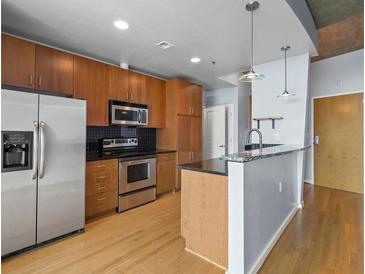 Open kitchen with stainless steel appliances, dark countertops, and a breakfast bar at 923 Peachtree Ne St # 1334, Atlanta, GA 30309