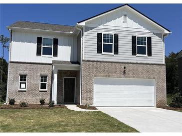 Charming two-story home featuring brick and siding exterior, a two-car garage, and well-manicured lawn at 2399 Argento Cir, Dacula, GA 30019