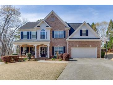 Charming two-story brick home with a well-manicured lawn and a two-car garage, showcasing curb appeal at 4803 Austin Hills Dr, Suwanee, GA 30024