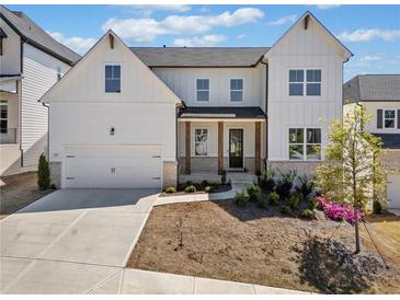 Charming two-story home with white siding, a two-car garage, and beautifully landscaped front yard at 117 Villanueva Rd, Woodstock, GA 30188