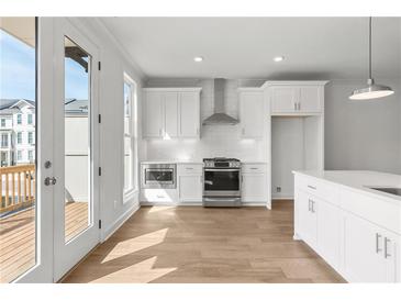 Bright kitchen features white cabinetry, stainless steel appliances, and hardwood flooring at 2340 Edgar Park Pl # 97, Duluth, GA 30096