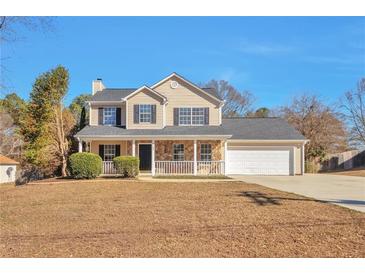 Charming two-story home featuring a welcoming front porch and a well-maintained lawn at 4785 Beaver Rd, Loganville, GA 30052