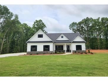 Charming single-story home with white siding, black shutters, and a lush green lawn at 490 Benson Meadows Dr, Dallas, GA 30157