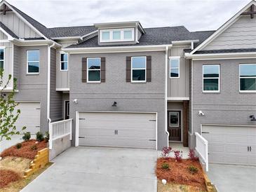 Charming townhome with a gray brick facade, two-car garage, and manicured landscaping at 1347 Fern Ridge Ct # 29, Norcross, GA 30093