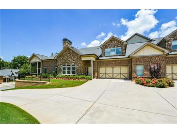 Beautiful brick home with well-manicured lawn, flower beds, and a concrete driveway leading to attached garages at 4845 Josie Way, Acworth, GA 30101