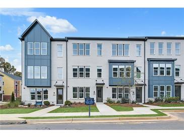 Modern townhouse featuring a gray brick facade, large windows, and well-manicured landscaping at 2637 Camphor Se Xing # 83, Smyrna, GA 30080