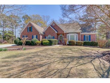 Charming brick home featuring a well-manicured lawn and mature landscaping that enhances its curb appeal at 1564 Beaver Creek Lane, Snellville, GA 30078