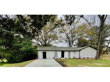 Charming one story home featuring a freshly painted exterior, well-manicured lawn, and newly paved driveway at 6123 Deerfield Ct, Morrow, GA 30260