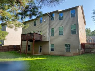 Spacious backyard view with a wooden deck overlooking the well-maintained lawn and privacy fence at 6802 Potomac, Fairburn, GA 30213