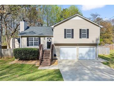 Charming split-level home features a well-manicured lawn, two-car garage, and inviting front porch at 2876 Davis Mill N Rd, Dallas, GA 30157