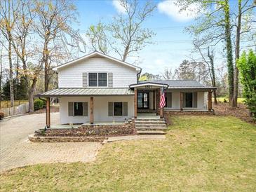 Charming two-story home featuring a landscaped front yard and inviting front porch at 5361 Seaton Way, Dunwoody, GA 30338