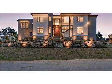 Modern two-story home featuring a stone retaining wall, a manicured lawn, and many large windows at 4232 Edgewood Ct, Marietta, GA 30068
