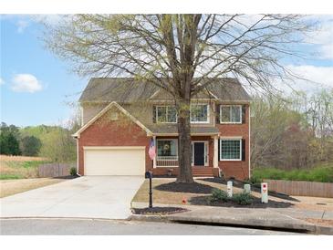 Charming two-story home featuring a brick facade, well-manicured lawn, and an attached two-car garage at 830 Buffington Way, Canton, GA 30115