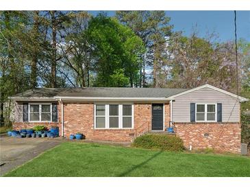 Charming brick home with a well-manicured lawn and inviting curb appeal in a mature neighborhood setting at 2434 Skyland Ne Trl, Brookhaven, GA 30319