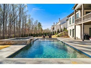 Backyard pool and spa with lush landscaping and comfortable seating area, perfect for relaxation and entertainment at 109 Owens Mill Pl, Canton, GA 30115