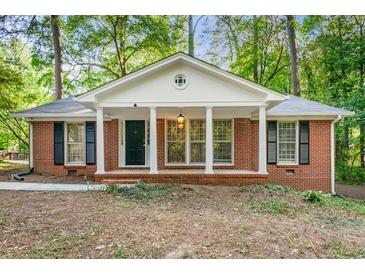 Charming one-story brick home featuring a classic front porch and manicured lawn surrounded by mature trees at 2612 Clairmont Ne Rd, Atlanta, GA 30329