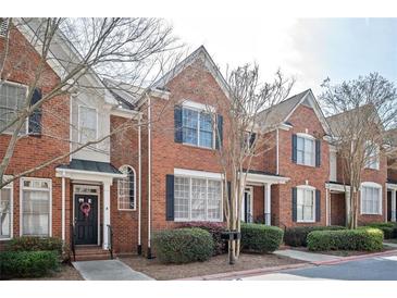 Charming brick townhome featuring a welcoming entryway, classic architecture, and well-maintained landscaping at 4743 Longcourt Se Dr, Atlanta, GA 30339