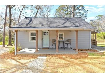 Charming home featuring a covered porch, light-blue front door, and neutral siding, set on a tree-lined lot at 119 Old Vandiver Dr, Canton, GA 30114