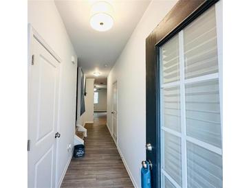 Bright hallway with wood-look flooring and neutral walls leading to various rooms within the home at 3132 Meadowstone Sw Ln, Atlanta, GA 30331