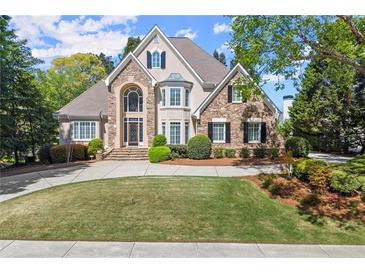 Beautiful two-story home featuring stone and stucco, well manicured landscaping, and a circular driveway at 2314 Edgemere Lake Cir, Marietta, GA 30062