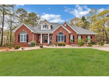 Charming brick home featuring a manicured lawn, black shutters, and a welcoming entrance at 315 Monroe Dr, Mcdonough, GA 30252