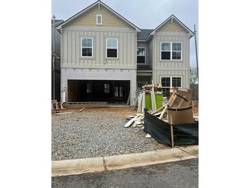 Under construction, this two-story home features large windows and a two-car garage awaiting completion at 329 Lakeside Court, Canton, GA 30114