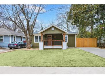 Charming bungalow featuring a well-manicured lawn and a welcoming front porch with wooden beams and railings at 2243 Newnan St, Atlanta, GA 30344