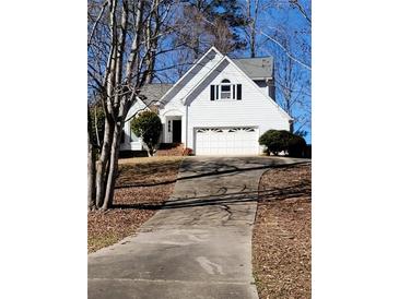 Charming two-story home featuring a symmetrical facade, attached garage, and well-maintained front yard with mature trees at 3503 Pine Grove Dr, Douglasville, GA 30135