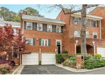 Charming brick townhouse featuring a two-car garage and manicured landscaping at 105 Jefferson Cir, Sandy Springs, GA 30328