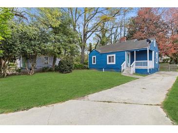 Charming blue home with a well-maintained front lawn and a concrete driveway at 5074 Park Ave, Forest Park, GA 30297