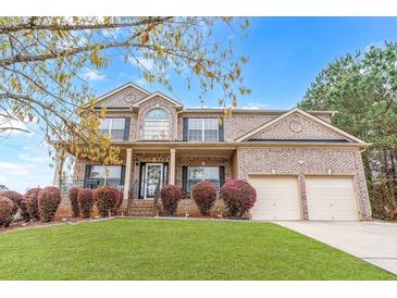 Charming two-story brick home with a manicured front lawn and attached two-car garage at 7847 Wrotham Cir, Atlanta, GA 30349