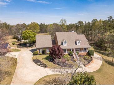 Beautiful brick home featuring a welcoming front porch, mature landscaping, and a spacious driveway at 8906 E Carroll Rd, Winston, GA 30187