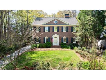 Beautiful brick two-story home with a well manicured green lawn and dark shutters at 1209 The By Ne Way, Atlanta, GA 30306
