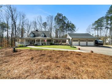 Charming home with a covered porch, three-car garage, and well-manicured lawn at 1064 Brooks Rackley Rd, Dallas, GA 30157