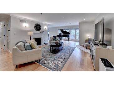 Spacious living room features a fireplace, piano, hardwood floors, and lots of natural light from the sliding glass doors at 3201 Lenox Rd Ne # 13, Atlanta, GA 30324