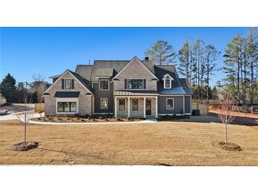 Stunning two-story home featuring a brick and siding exterior, professionally landscaped yard, and modern architectural details at 3819 Havenrock Dr, Marietta, GA 30066