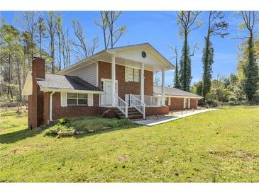 Charming brick home featuring a covered front porch, classic architecture, and lush front yard at 4444 Casco Nw Ln, Lilburn, GA 30047