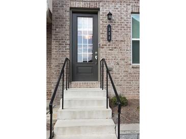 Inviting front door with brick facade, black handrails, and a stylish door number plaque at 308 Overture Ct, Smyrna, GA 30080