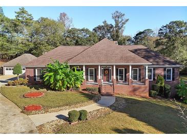 Charming brick home with a landscaped front yard, mature trees, and a welcoming front porch at 1431 Brandy Shoals Se Ct, Conyers, GA 30013