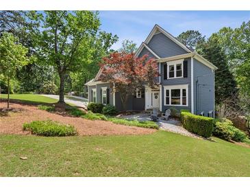 Charming two-story home with blue siding, manicured lawn, and inviting front entrance at 1904 Woodland Hills Nw Ave, Atlanta, GA 30318