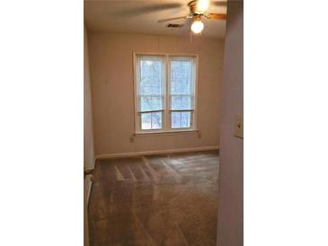 Bright bedroom with neutral carpet, ceiling fan, and a large window bringing in lots of natural light at 1034 Bettina Ct, Mableton, GA 30126