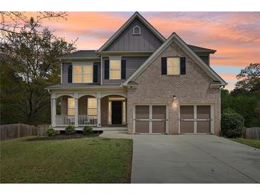 Charming two-story home with brick and siding, a welcoming porch, and a two-car garage at 105 Oakfield Way, Douglasville, GA 30134
