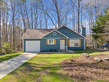 Charming single-Gathering home with blue siding, attached garage, and well-manicured lawn on a sunny day at 109 Beaver Dam Rd, Peachtree City, GA 30269