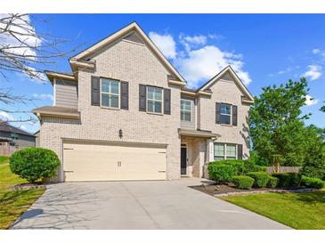Charming two-story brick home with a two-car garage and well-manicured landscaping at 3048 Level Grove Ln, Dacula, GA 30019