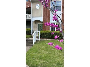 Inviting two-story condo featuring a well-maintained lawn and charming green door with decorative wreath at 1731 Pryor Sw Rd # 108, Atlanta, GA 30315
