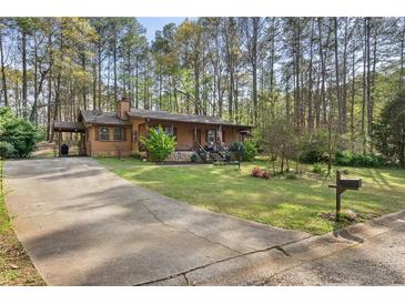 Charming home with a long driveway and a beautiful, well-maintained front yard with mature trees at 615 Upland Nw Trl, Conyers, GA 30012