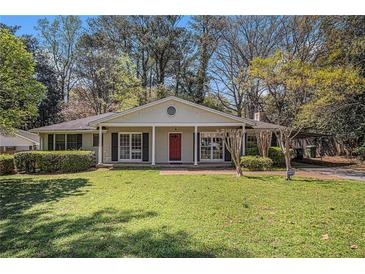 Charming single-story home with a well-manicured lawn, a red front door and a covered front porch at 2992 Westminster Nw Cir, Atlanta, GA 30327
