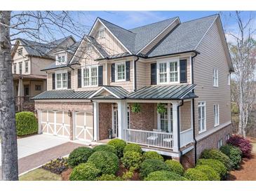 Beautiful two-story home featuring a brick facade, a two-car garage, and a welcoming front porch at 3225 Suffolk Dr, Cumming, GA 30041