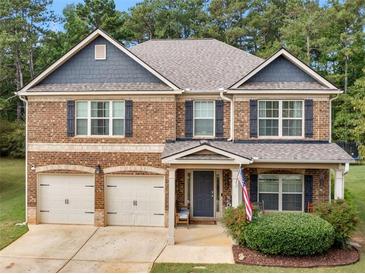 Two-story brick home with a two-car garage, covered porch, and manicured landscaping at 346 M J Mccarthy Way, Hampton, GA 30228